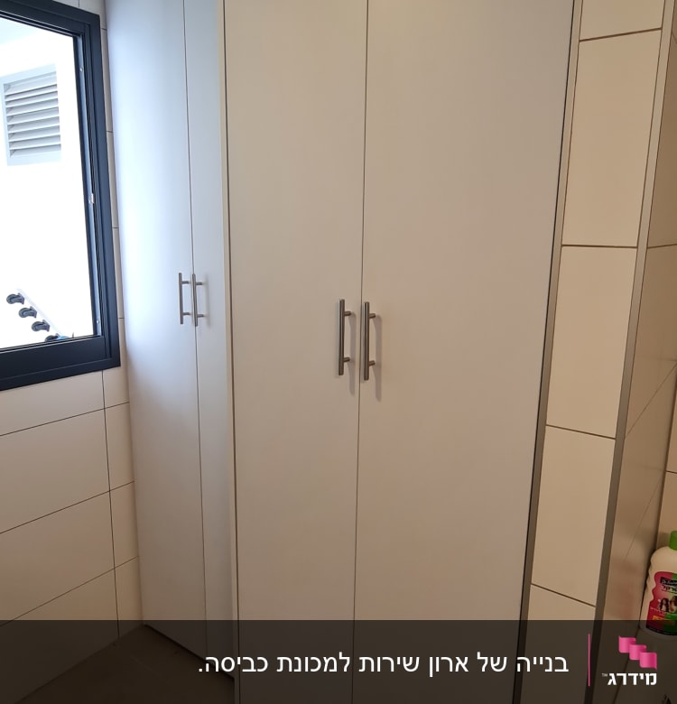 ארון לבן עם ידיות מתכת בחדר